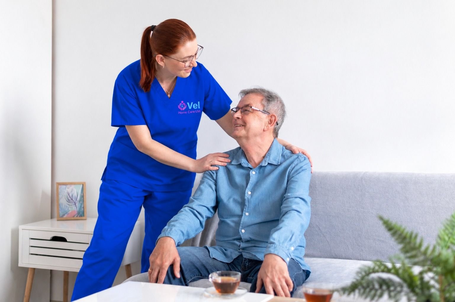 A carer sharing a relaxed moment with an older man at home