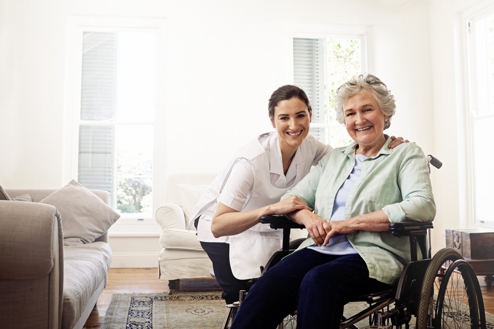 A smiling carer providing personal support to a wheelchair user at home